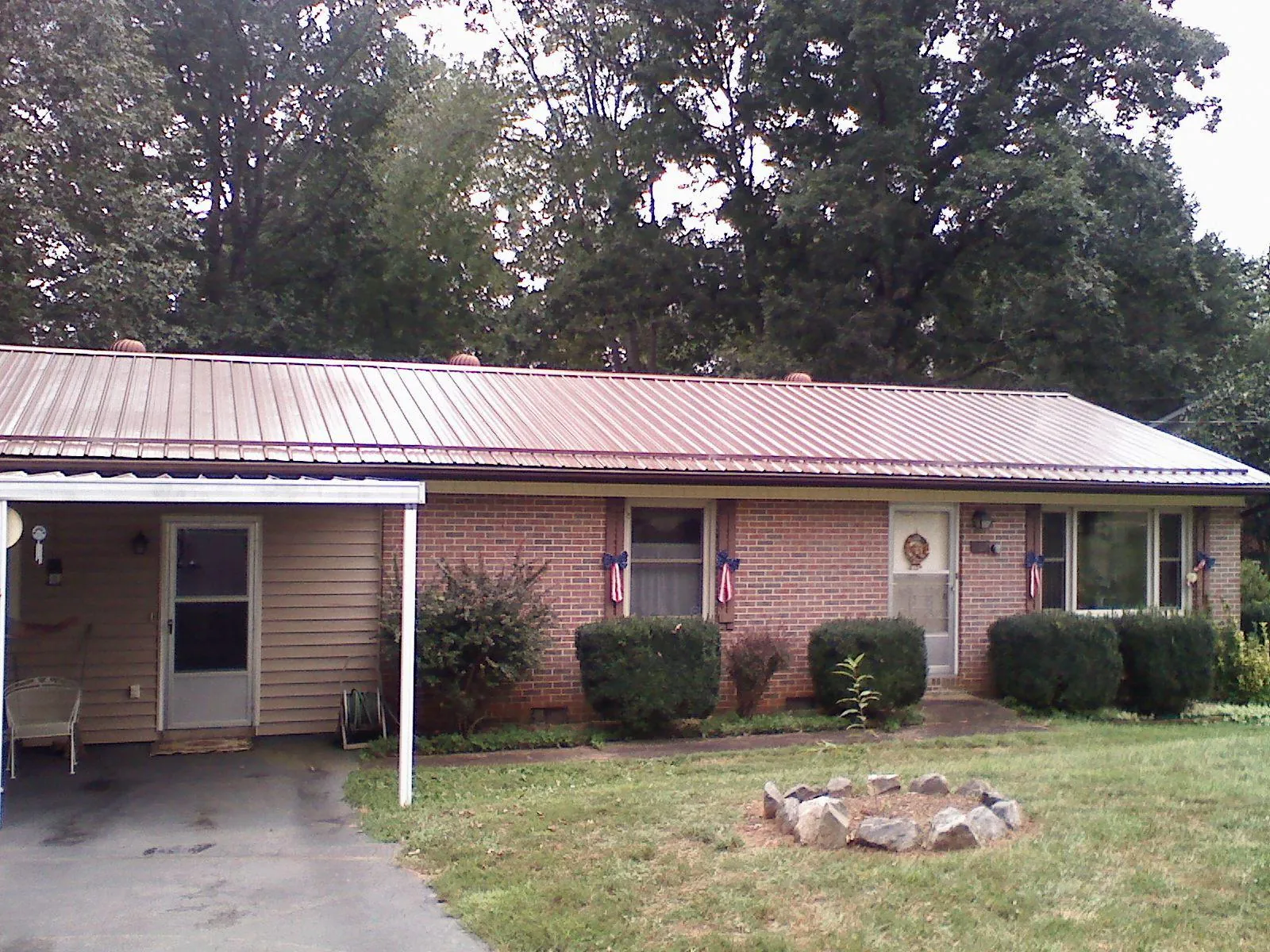 Bronze metal roof and carport on a brick ranch home — Roof Repair work by our crew in Callensburg